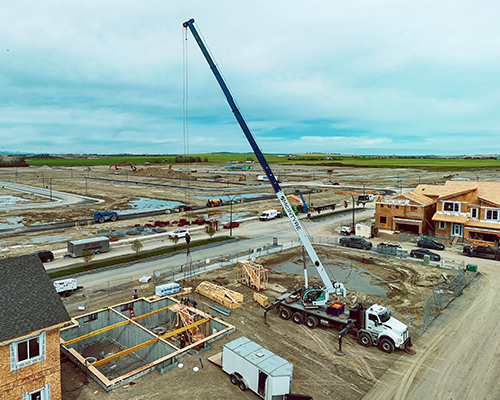 McIntyre Crane mobile crane hoisting materials on Calgary residential construction site