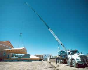McIntyre Crane lifting prefabricated roof section with mobile crane in Calgary construction site